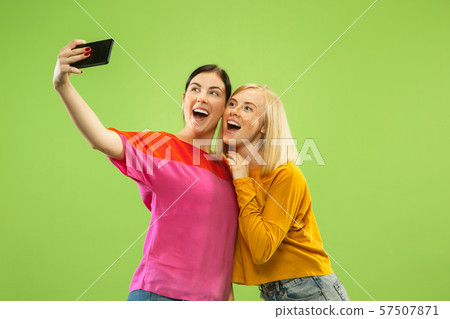 Portrait of pretty girls isolated on green studio background 57507871