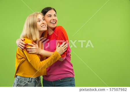 Portrait of pretty girls isolated on green studio background 57507982