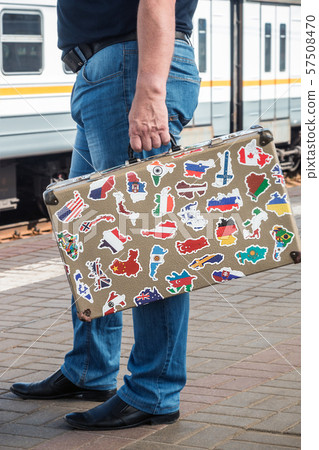 suitcase with stickers from around the world stands on the platform of the railway station suitcase with stickers from around the world stands on the platform of the railway station 57508470