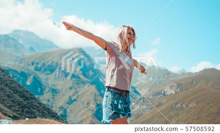 Woman hiking in mountains at sunny day time 57508592
