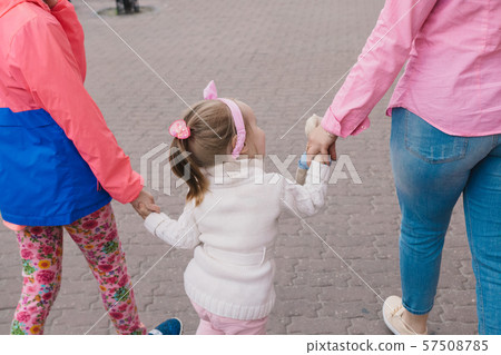Happy mother and her children are walking around 57508785