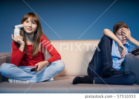 Gaming concept. Tired children on sofa with game joysticks 57510353