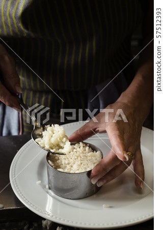 woman filling a mold with cooked rice woman filling a mold with cooked rice 57512393