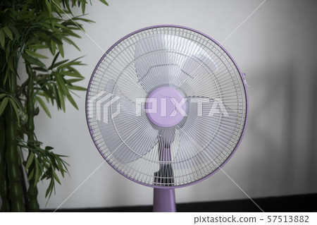 Modern violet electric fan in a living room saving peoples from hot temperature in summer days. Modern violet electric fan in a living room saving peoples from hot temperature in summer days. 57513882