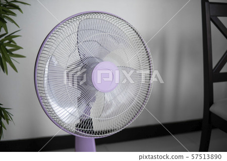 Modern violet electric fan in a living room saving peoples from hot temperature in summer days. Modern violet electric fan in a living room saving peoples from hot temperature in summer days. 57513890