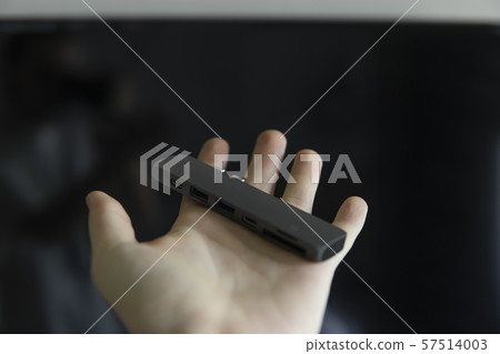 Man's hand holding The USB adapter under the Type-C connector for laptop. Multiport station for 57514003