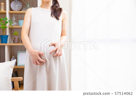 Pregnant woman scratching stomach Pregnant woman scratching stomach 57514062