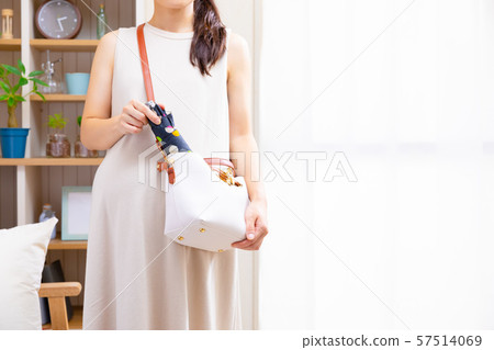 Pregnant woman putting folding umbrella in cage Pregnant woman putting folding umbrella in cage 57514069