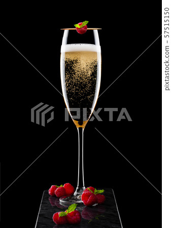 Elegant glass of yellow champagne with rasspbery Elegant glass of yellow champagne with rasspbery 57515150