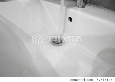 Running water from modern stainless steel faucet in white sink. Counter bathroom interior Running water from modern stainless steel faucet in white sink. Counter bathroom interior 57515187