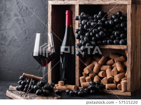 Bottle of red wine with dark grapes and corks Bottle of red wine with dark grapes and corks 57515220