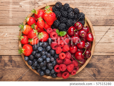 Fresh organic summer berries mix in round wooden 57515280