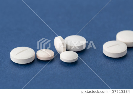 different white pills on blue background 57515384