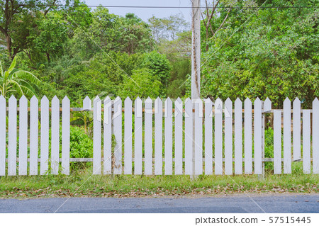 Old white wooden fence with a broken board at the roadside area Old white wooden fence with a broken board at the roadside area 57515445