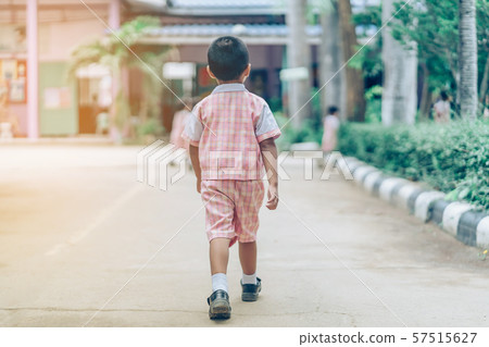 Back view of Boy followed girl friends on street to go to the classroom in school. 57515627