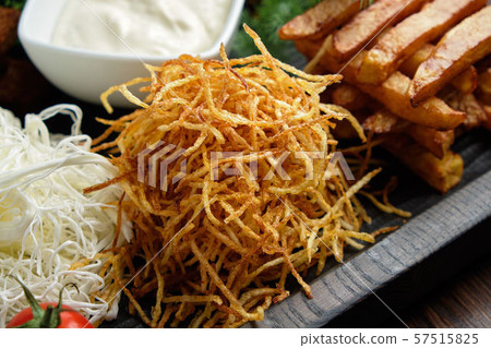 Hot appetizer on a wooden black plate on a dark wooden background. Restaurant menu 57515825