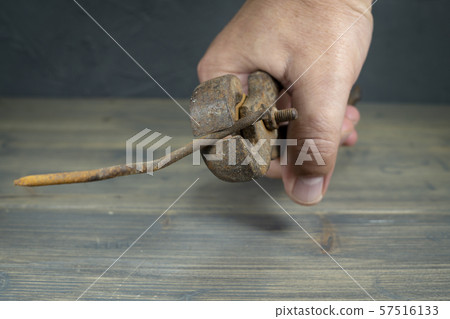 Male hand holding rusty grips and bent nail 57516133