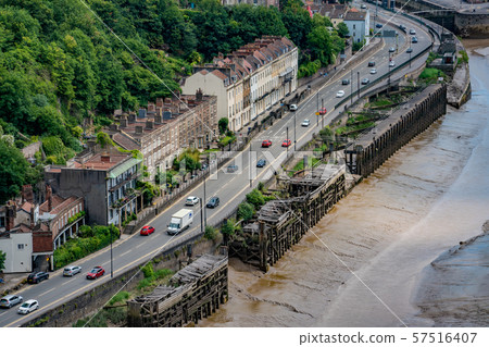 View of a street with houses and cars going by 57516407