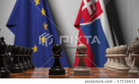 Flags of the EU and Slovakia behind chess board. The first pawn moves in the beginning of the game 57516611
