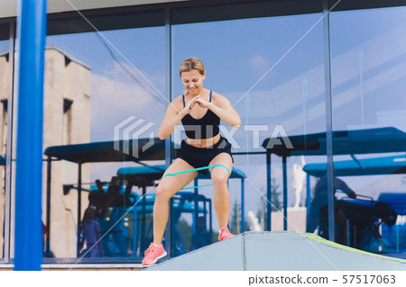 Profile view of a female athlete doing some tricep dips on a park bench. Profile view of a female athlete doing some tricep dips on a park bench. 57517063