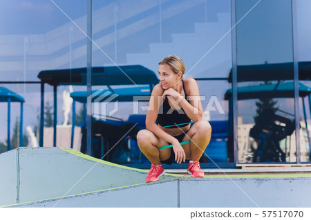 Profile view of a female athlete doing some tricep dips on a park bench. Profile view of a female athlete doing some tricep dips on a park bench. 57517070