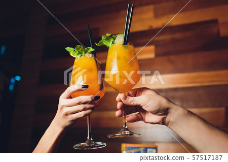 women raising a glasses of aperol spritz at the dinner table. 57517187