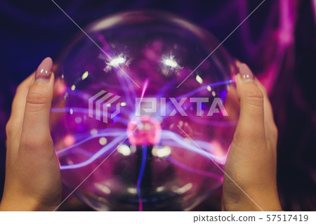 Hand touching a plasma ball with smooth magenta-blue flames. Hand touching a plasma ball with smooth magenta-blue flames. 57517419