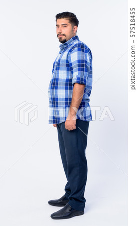 Full body shot profile view of bearded Persian hipster man looking at camera Full body shot profile view of bearded Persian hipster man looking at camera 57518455