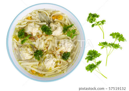 Chicken broth with egg noodles and meatballs. 57519132