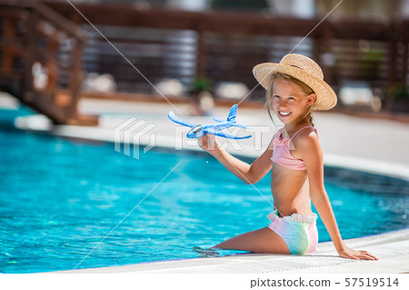 Adorable little girl swimming at outdoor swimming pool 57519514
