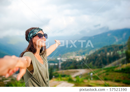 Beautiful happy young woman in mountains in the background of fog 57521390