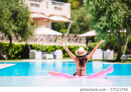Beautiful young woman relaxing in swimming pool. 57521708