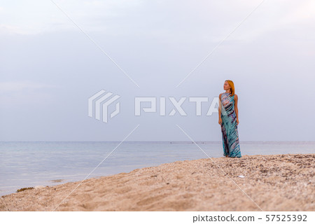 Young red woman on a beach Young red woman on a beach 57525392