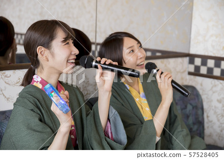 做一個婦女的旅行的婦女在卡拉OK演唱在溫泉旅館的卡拉OK演唱室休息室 做一個婦女的旅行的婦女在卡拉OK演唱在溫泉旅館的卡拉OK演唱室休息室 57528405