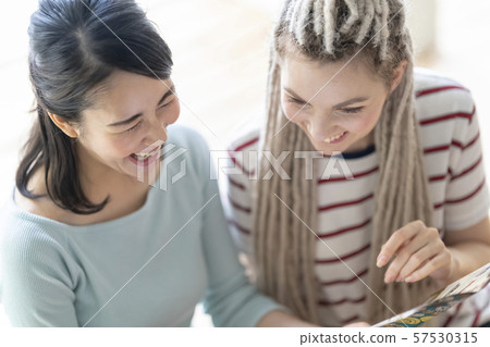 Japanese and Russians laughing at photos when they were studying abroad 57530315