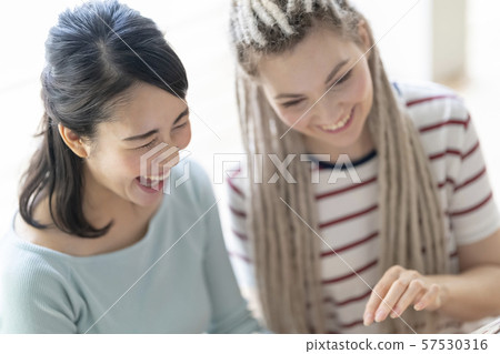 Japanese and foreigners laughing at the photos of studying abroad 57530316