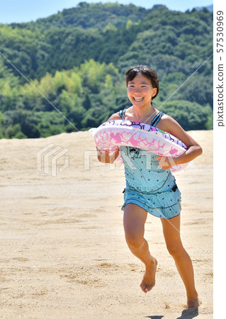 Girls running on the beach (sea bathing, bathing suit) 57530969