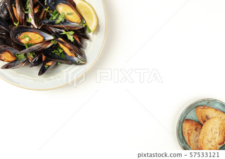 Marinara mussels, moules mariniere, shot from the top on a white background with toasted bread and 57533121