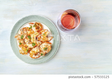 Cooked shrimps, shot from the top on a rustic wooden background with a glass of rose wine and a 57533125