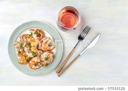 Shrimps, shot from above on a rustic wooden background with a glass of rose wine and copy space 57533128