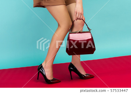 Woman shapely legs wearing black lacquered high Woman shapely legs wearing black lacquered high 57533447