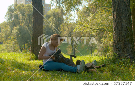 Attractive woman and her dog in the park Attractive woman and her dog in the park 57537147