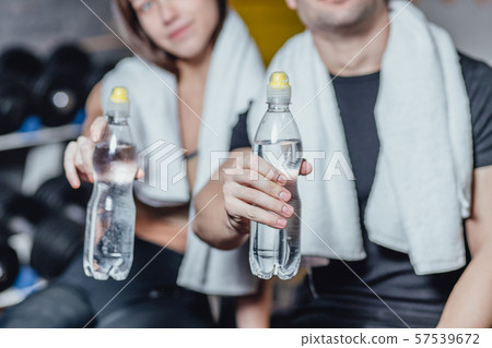 Portrait of a healthy young couple while training. Young people adhere to drinking regime during Portrait of a healthy young couple while training. Young people adhere to drinking regime during 57539672