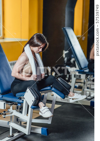 Beautiful sport girl is engaged on a simulator in the gym. Pretty girl with the beautiful tightened 57539749
