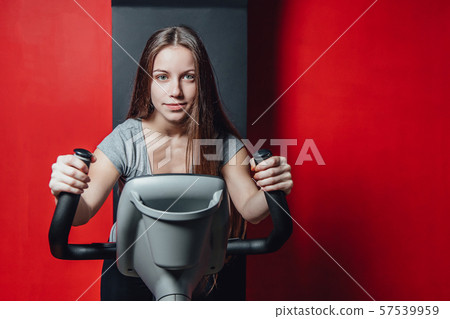 Exercise a bike cardio workout in a fitness room woman, taking a weight loss machine with aerobic Exercise a bike cardio workout in a fitness room woman, taking a weight loss machine with aerobic 57539959
