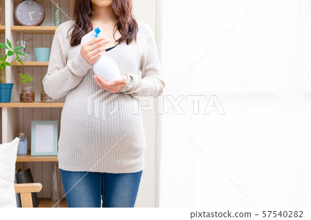 Pregnant woman with disinfectant spray Pregnant woman with disinfectant spray 57540282