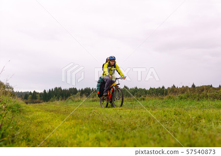 cyclist traveler rides through an autumn meadow on 57540873