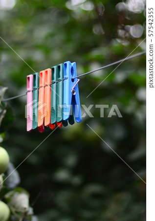 Clothespins on a rope hanging outside house and Clothespins on a rope hanging outside house and 57542355