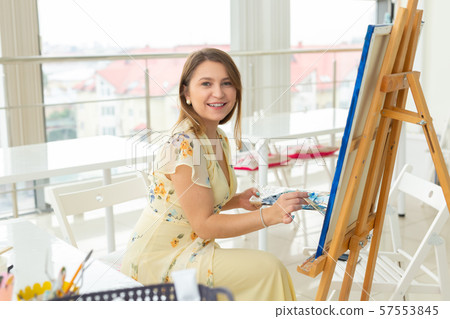 Art class and drawing concept - Woman artist working on painting in studio. 57553845