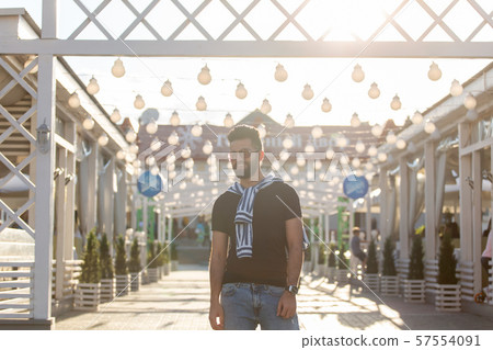 Handsome cheerful young arabian student with a stylish mustache and a beard walking around the city Handsome cheerful young arabian student with a stylish mustache and a beard walking around the city 57554091